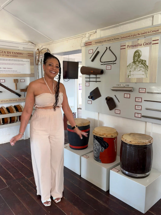 Surensca van NuviaSol danst lachend de Tambú in het Museo di Tambú Shon Cola op Curaçao, stralend van vrijheid en zelfvertrouwen.
